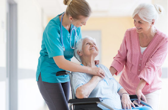 Woman In A Wheelchair With Friend And Nurse