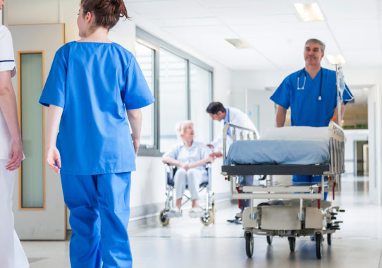 Hospital Corridor With Porter Brining Hospital Bed Down